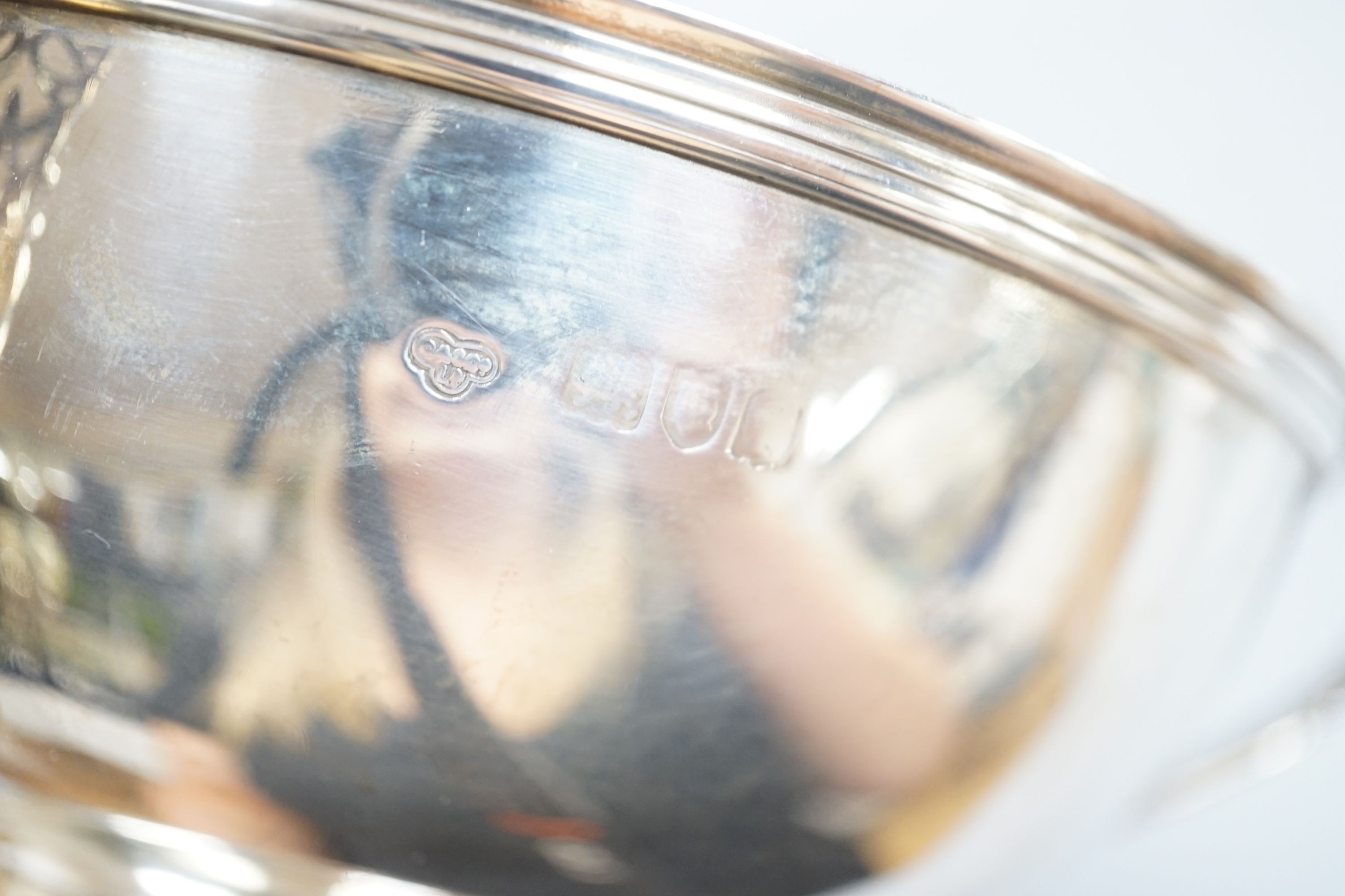 An Edwardian silver circular bowl, with three piece harp shape handles, Goldsmiths & Silversmiths Co Ltd, London 1906, on pedestal foot, diameter 16.25cm, 14oz.